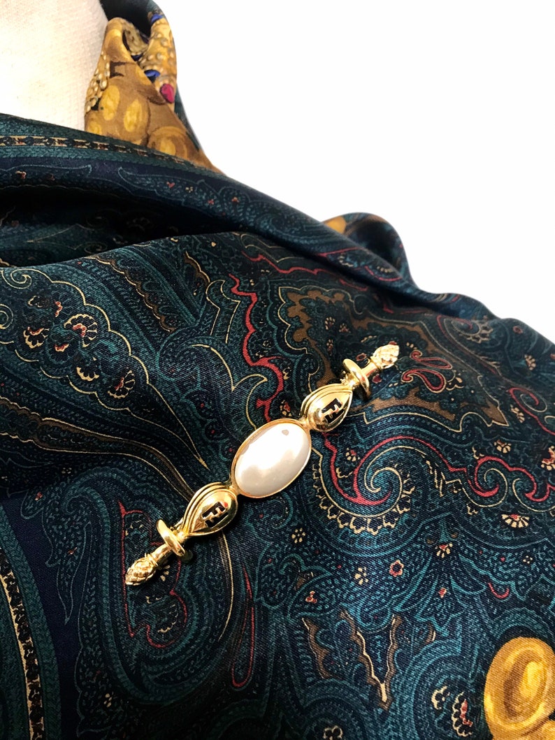 FENDI   gold tone hat pin with white oval faux pearl and FF mark